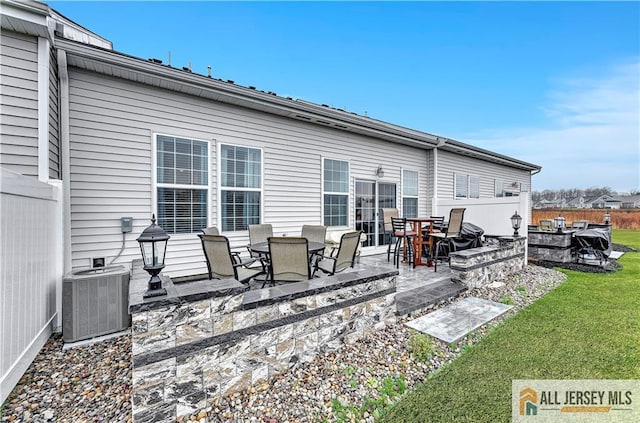back of house featuring central air condition unit, fence, a patio, and a yard