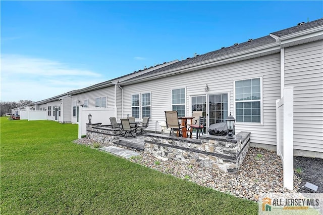 rear view of house with a patio and a lawn