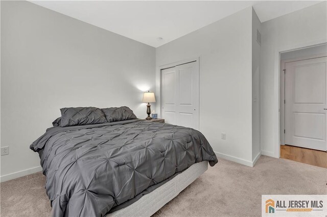 bedroom featuring carpet floors, baseboards, visible vents, and a closet