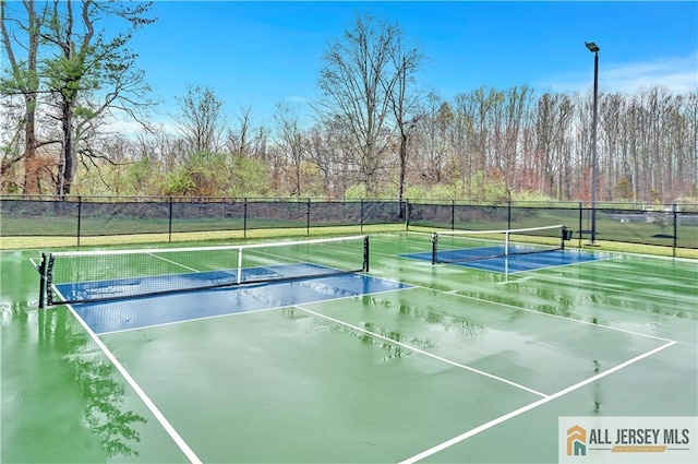 view of tennis court featuring fence