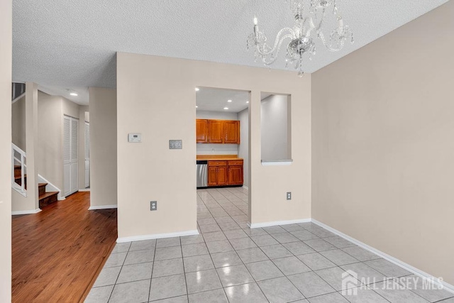 47 Covington Ct, East Brunswick, NJ 08816 - empty room with a chandelier, a textured ceiling, light tile patterned floors, stairway, and recessed lighting