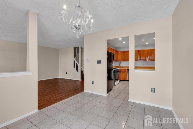 47 Covington Ct, East Brunswick, NJ 08816 - unfurnished room with light tile patterned floors, a chandelier, a textured ceiling, stairs, and recessed lighting