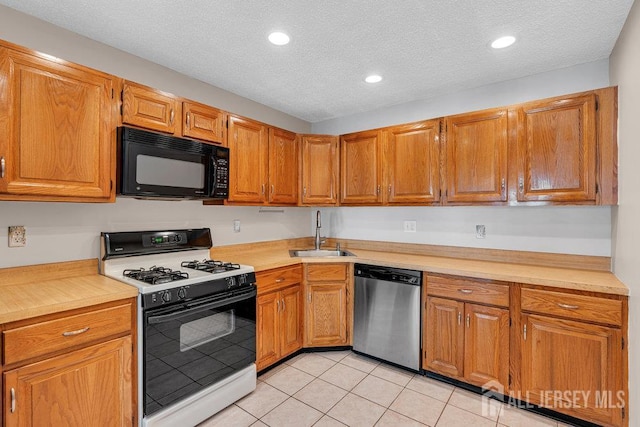 47 Covington Ct, East Brunswick, NJ 08816 - kitchen with range with gas cooktop, black microwave, dishwasher, light tile patterned floors, and light countertops