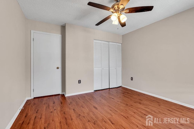47 Covington Ct, East Brunswick, NJ 08816 - unfurnished bedroom featuring wood finished floors, a textured ceiling, a closet, and a ceiling fan