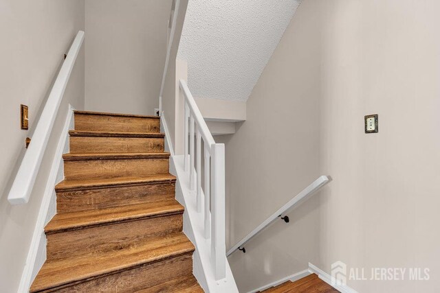 47 Covington Ct, East Brunswick, NJ 08816 - staircase featuring a textured ceiling