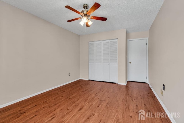 47 Covington Ct, East Brunswick, NJ 08816 - unfurnished bedroom featuring wood finished floors, a textured ceiling, a closet, and ceiling fan