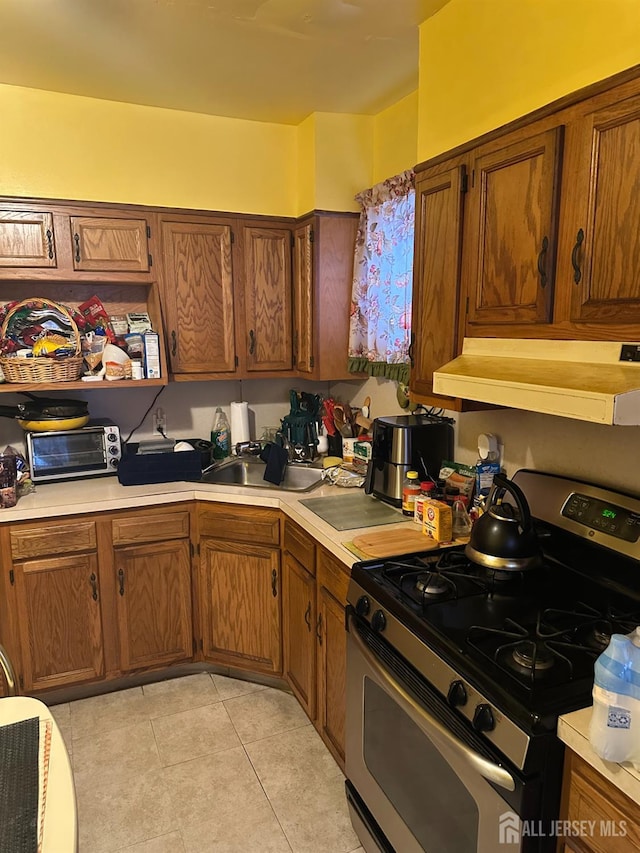 359 Parkway Ave, Trenton, NJ 08618 - kitchen with stainless steel range with gas stovetop, under cabinet range hood, light countertops, and brown cabinets