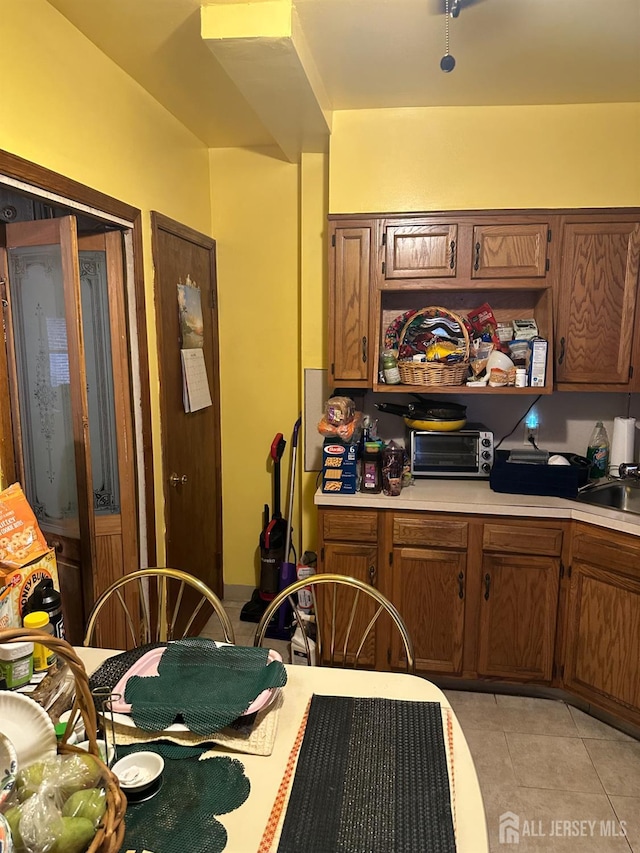 359 Parkway Ave, Trenton, NJ 08618 - kitchen featuring light countertops, light tile patterned floors, and brown cabinets