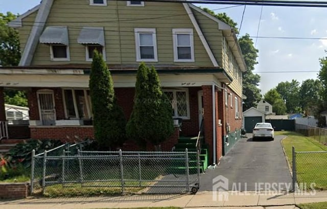 359 Parkway Ave, Trenton, NJ 08618 - dutch colonial with brick siding, a detached garage, a fenced front yard, and a gambrel roof