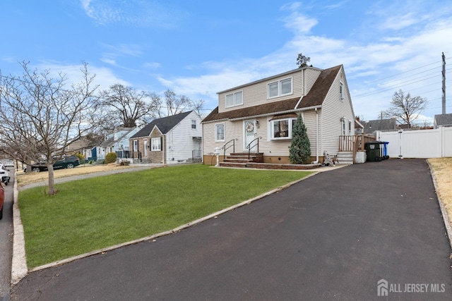 view of front of property with a front lawn, driveway, fence, roof with shingles, and crawl space