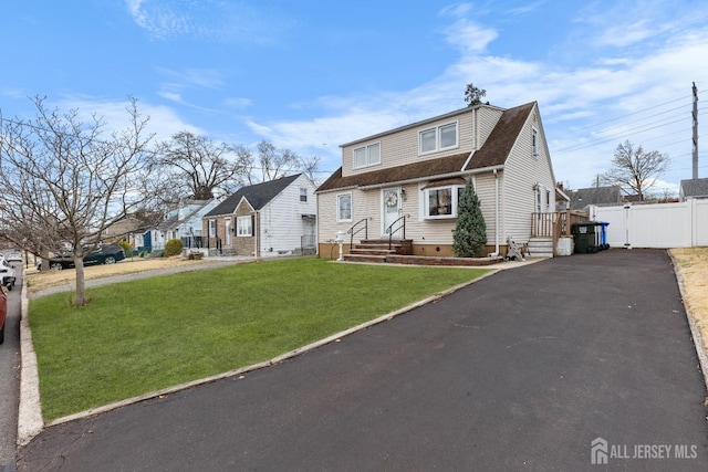 view of front of property featuring a front yard, roof with shingles, fence, aphalt driveway, and crawl space