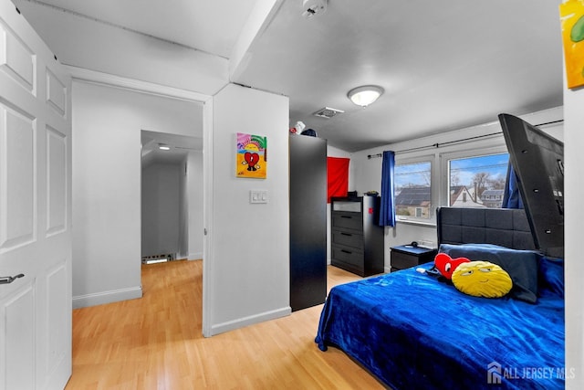 bedroom with baseboards, visible vents, and light wood-style flooring