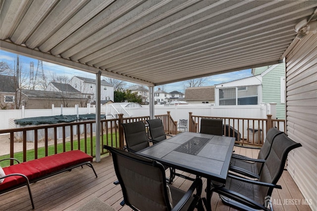 wooden terrace featuring outdoor dining area and a fenced backyard