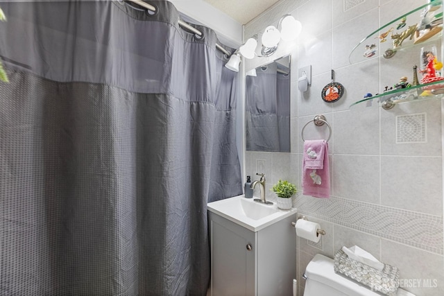 bathroom featuring tile walls, toilet, vanity, and a shower with curtain