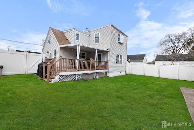 back of property with a fenced backyard, a lawn, a deck, and crawl space