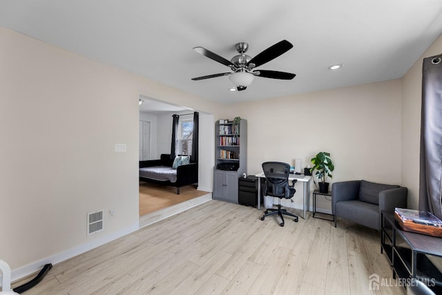 home office with visible vents, baseboards, wood finished floors, and a ceiling fan