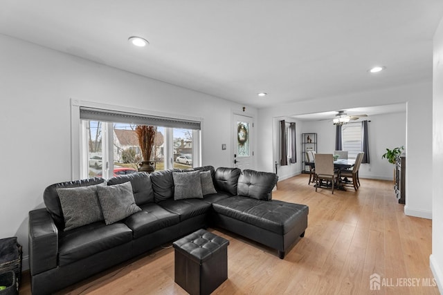 living room featuring recessed lighting, baseboards, ceiling fan, and light wood-type flooring