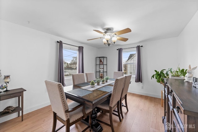 dining space with baseboards, light wood finished floors, and ceiling fan