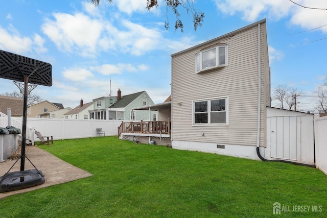 rear view of house with crawl space, a yard, a wooden deck, and a fenced backyard