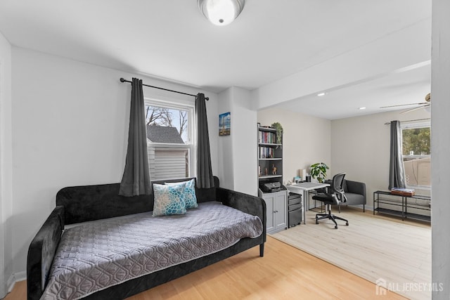 sitting room featuring a ceiling fan, baseboards, and light wood finished floors