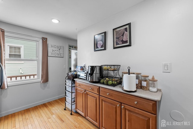 bar featuring light wood-style floors and baseboards