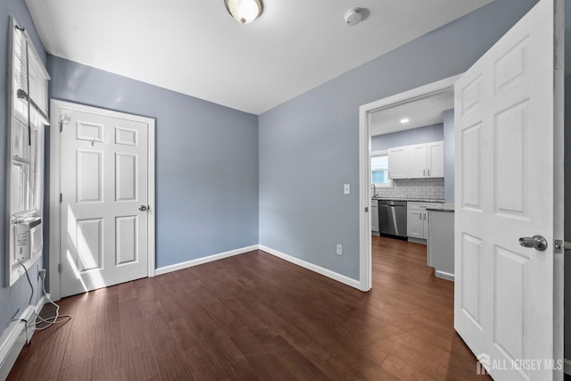 41 Guilden St, New Brunswick, NJ 08901 - empty room featuring a smoke detector, dark wood-style flooring, and a baseboard radiator