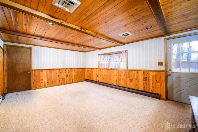 unfurnished room featuring beamed ceiling, visible vents, a baseboard heating unit, wooden ceiling, and wainscoting