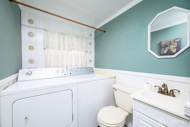 bathroom featuring vanity, a wainscoted wall, ornamental molding, toilet, and washer and clothes dryer