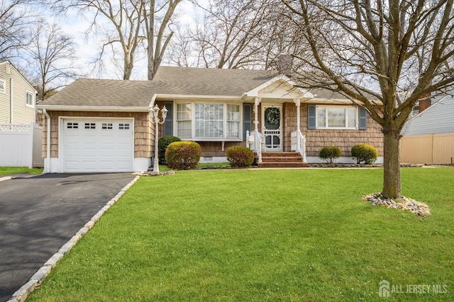 ranch-style house featuring fence, driveway, a shingled roof, a front lawn, and a garage