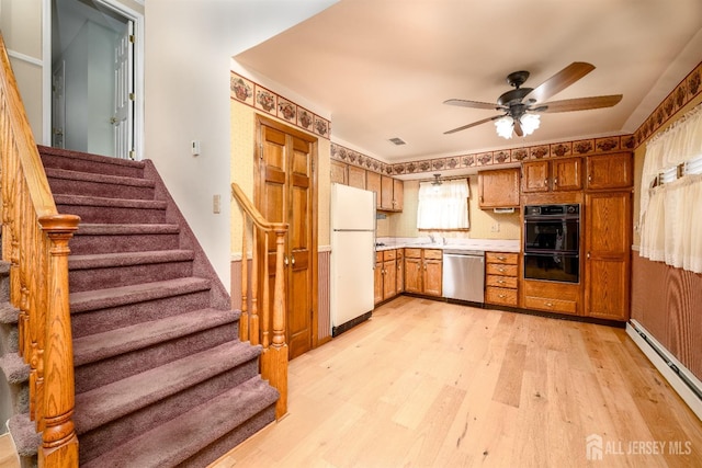 kitchen featuring light wood-style flooring, a baseboard heating unit, freestanding refrigerator, dishwasher, and ceiling fan