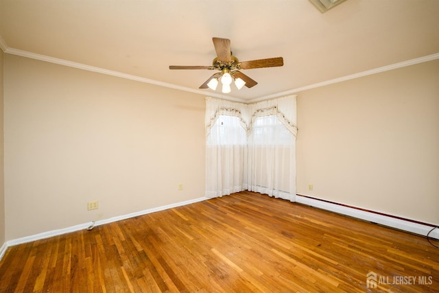 unfurnished room featuring baseboards, wood finished floors, and crown molding