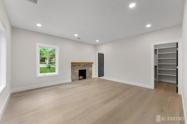 116 Hunt Dr, Princeton, NJ 08540 - unfurnished living room with light wood-type flooring, a stone fireplace, recessed lighting, and baseboards