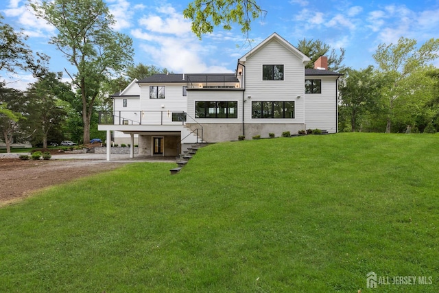 116 Hunt Dr, Princeton, NJ 08540 - back of property with dirt driveway, a lawn, a balcony, a chimney, and stairway