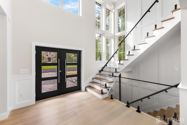 116 Hunt Dr, Princeton, NJ 08540 - foyer entrance with a towering ceiling, a decorative wall, stairs, french doors, and wood finished floors