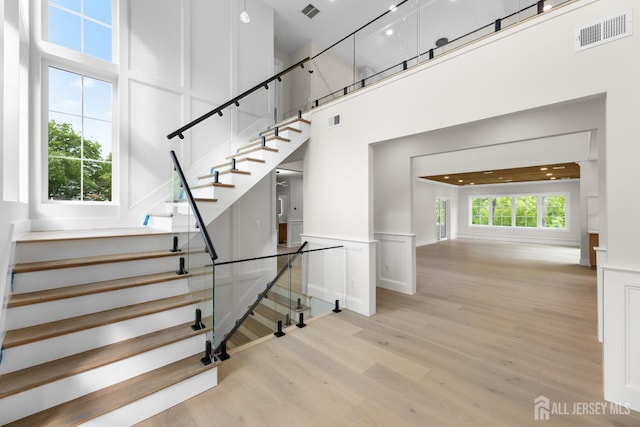 116 Hunt Dr, Princeton, NJ 08540 - stairs featuring a decorative wall, wood finished floors, a high ceiling, and wainscoting