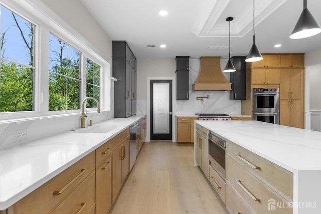 116 Hunt Dr, Princeton, NJ 08540 - kitchen with custom range hood, a sink, appliances with stainless steel finishes, light wood finished floors, and light stone counters