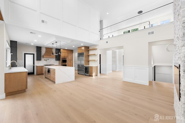 116 Hunt Dr, Princeton, NJ 08540 - unfurnished living room with a towering ceiling, light wood finished floors, a decorative wall, and wine cooler