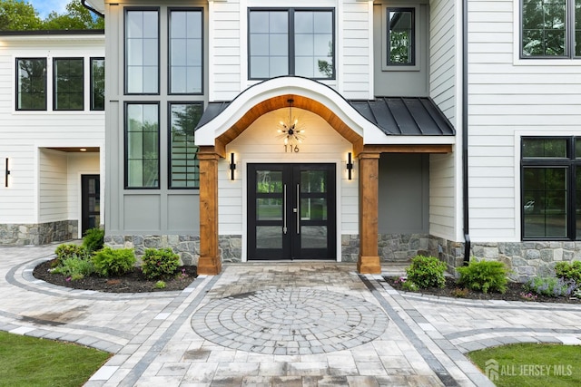 116 Hunt Dr, Princeton, NJ 08540 - view of exterior entry featuring french doors, stone siding, a standing seam roof, and metal roof