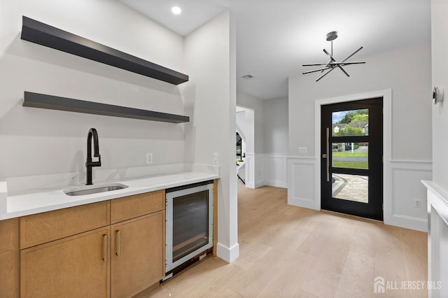 116 Hunt Dr, Princeton, NJ 08540 - kitchen with open shelves, beverage cooler, a sink, light wood-style flooring, and wainscoting