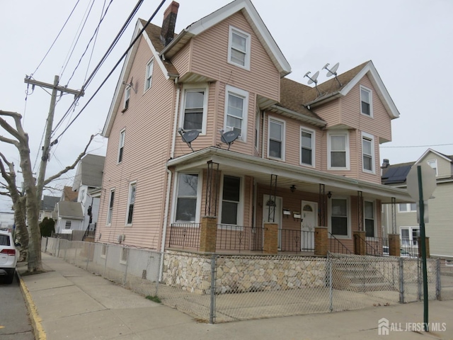 87-89 1st St, Perth Amboy, NJ 08861 - view of front of property featuring covered porch, a chimney, and a fenced front yard