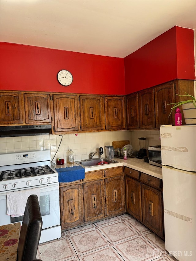 87-89 1st St, Perth Amboy, NJ 08861 - kitchen with backsplash, a sink, tile countertops, under cabinet range hood, and white appliances