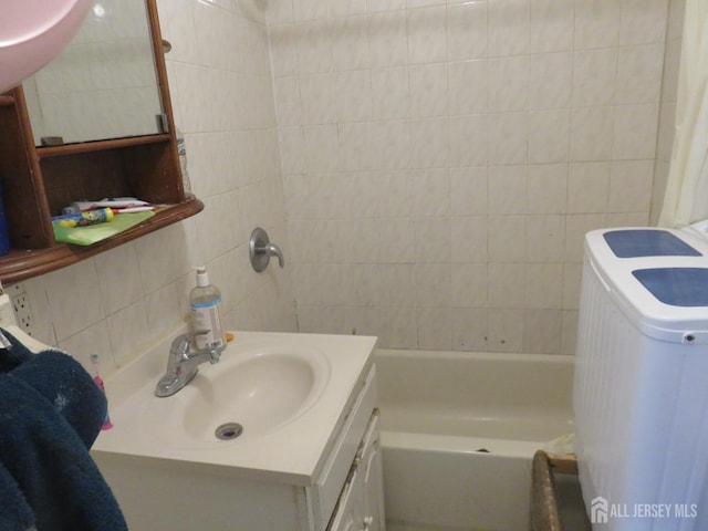 bathroom with decorative backsplash, tile walls, and vanity