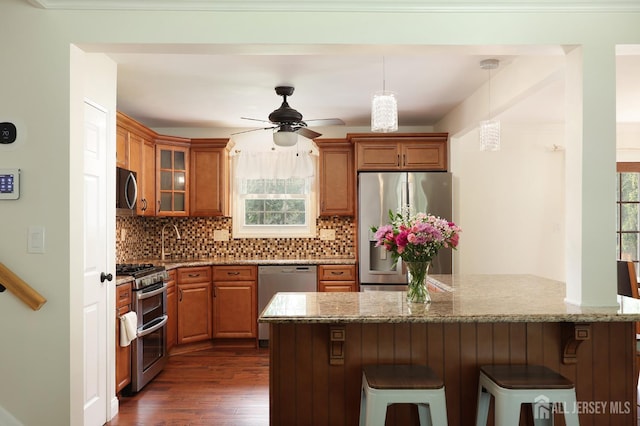 505 Runyon Ave, Piscataway, NJ 08854 - kitchen featuring appliances with stainless steel finishes, brown cabinets, dark wood-type flooring, ceiling fan, and a breakfast bar area