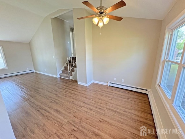 43 Overbrook Dr, Colonia, NJ 07067 - unfurnished living room with baseboard heating, wood finished floors, a baseboard radiator, baseboards, and vaulted ceiling