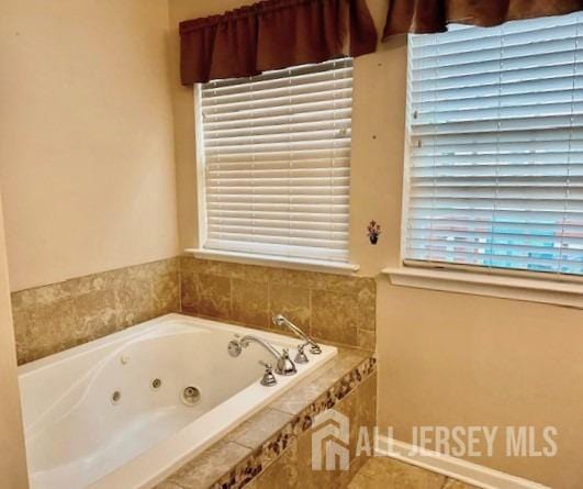 bathroom featuring a jetted tub, tile patterned flooring, and baseboards