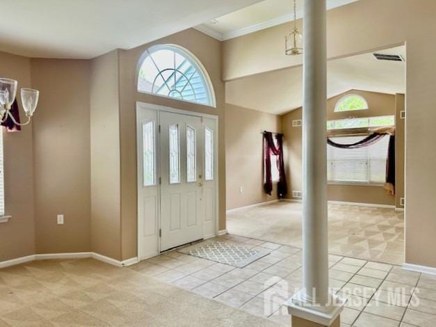 entryway featuring ornate columns, healthy amount of natural light, light carpet, baseboards, and crown molding
