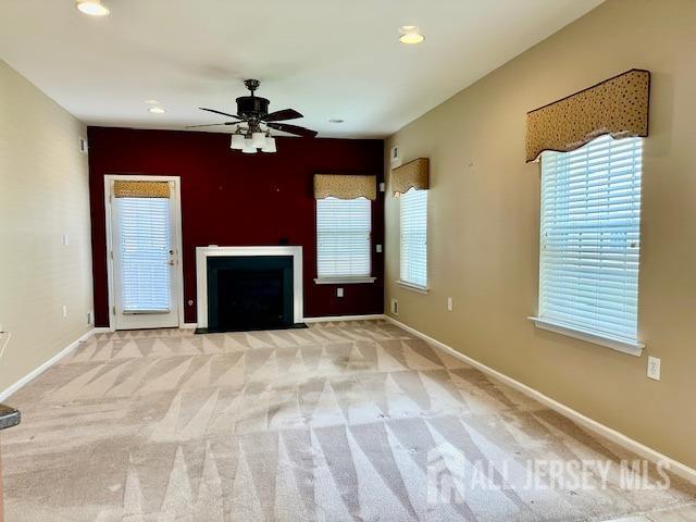 unfurnished living room with a ceiling fan, baseboards, carpet, and recessed lighting