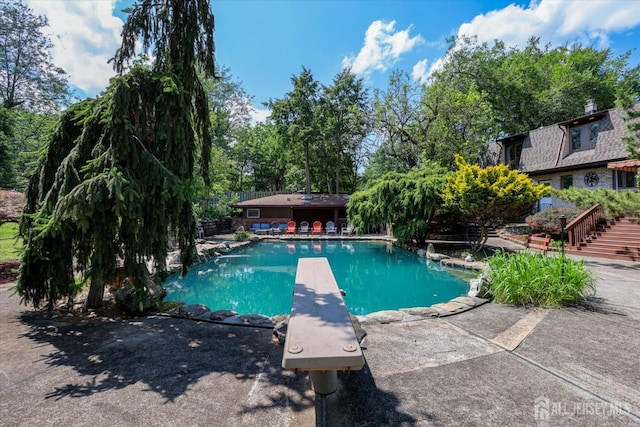 403 New Dover Rd, Colonia, NJ 07067 - swimming pool featuring a diving board, a patio area, and view of scattered trees