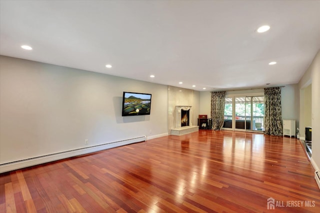 403 New Dover Rd, Colonia, NJ 07067 - unfurnished living room with baseboard heating, wood finished floors, recessed lighting, and a warm lit fireplace