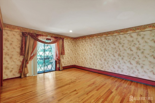 403 New Dover Rd, Colonia, NJ 07067 - empty room featuring wallpapered walls, light wood finished floors, and a baseboard heating unit